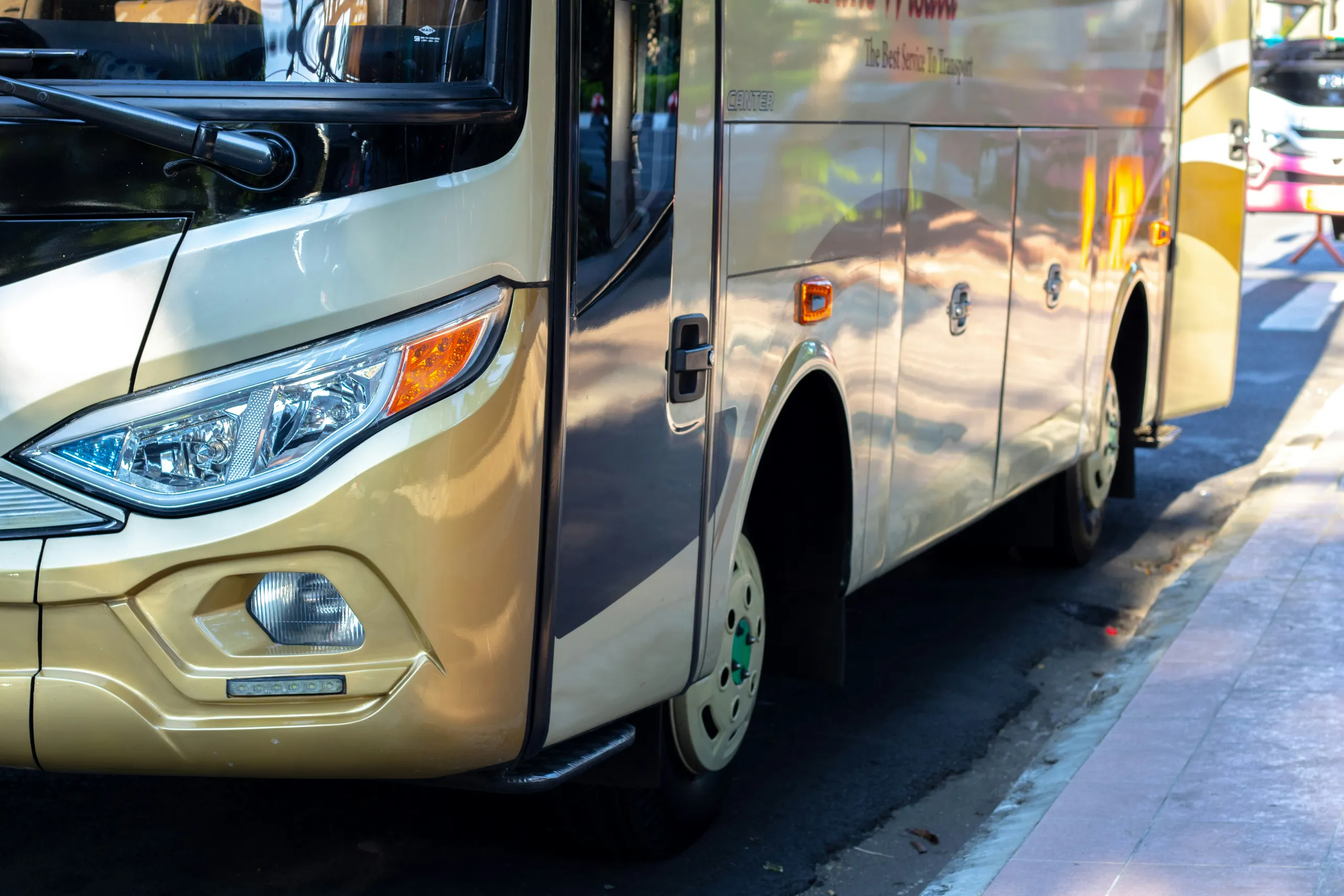 Gran autobús turístico dorado aparcado junto a la calle